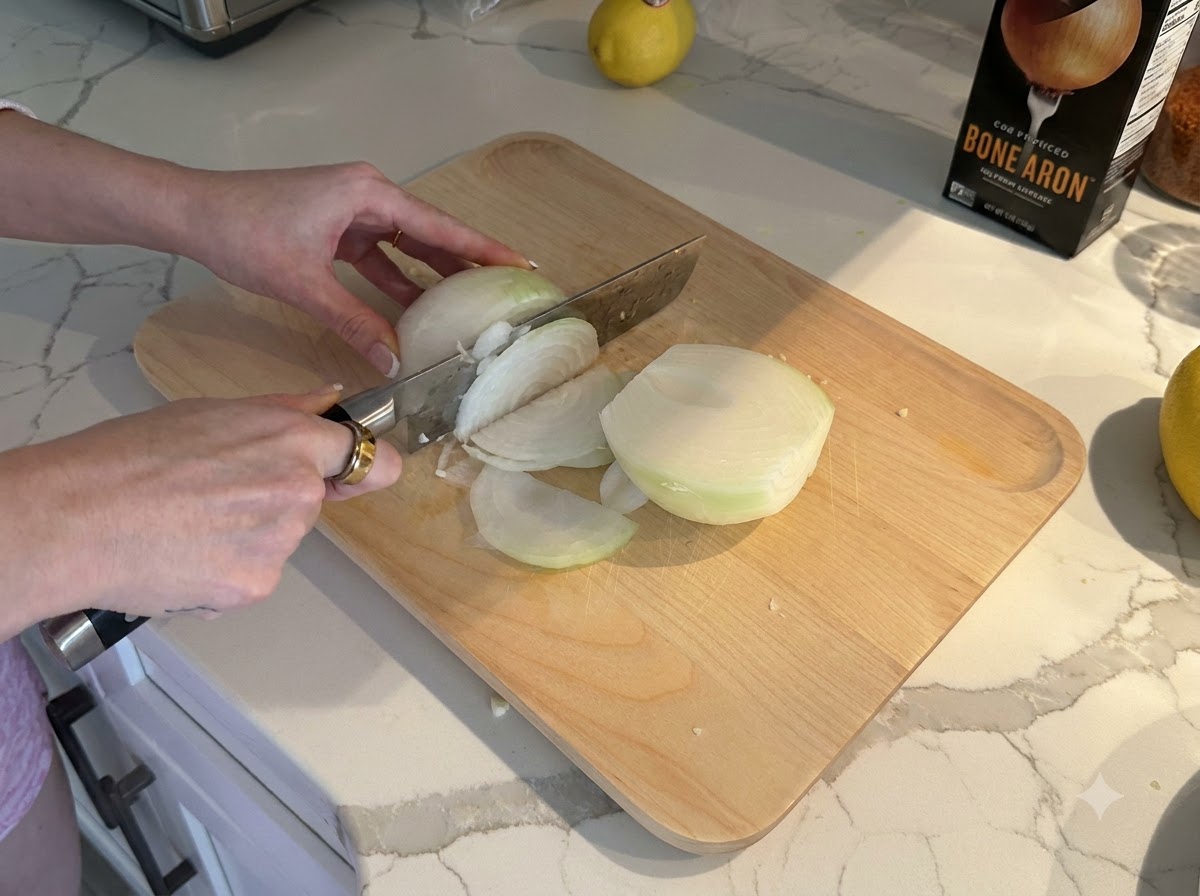 Una cipolla bianca affettata e tagliata a dadini piccoli su un tagliere di legno.