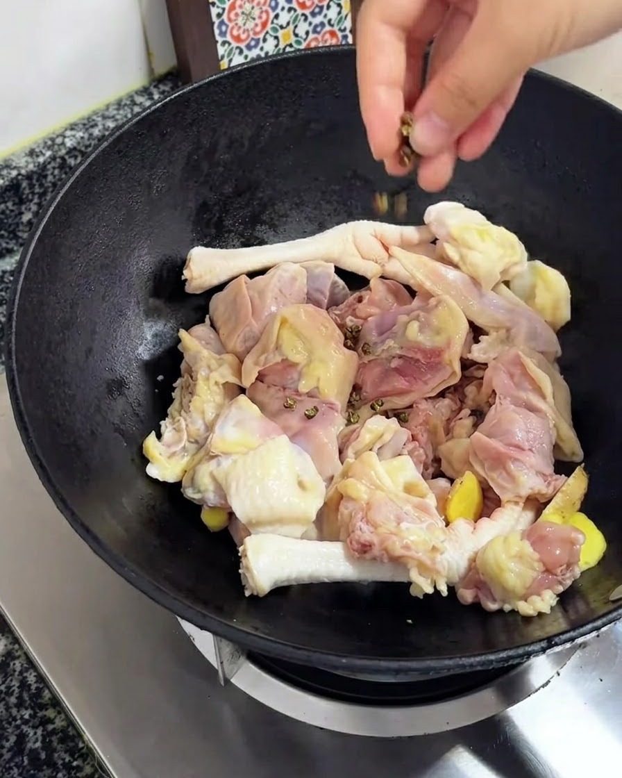 Pepe del Sichuan fatto cadere sul pollo e sullo zenzero nel wok.