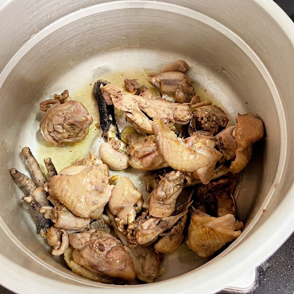 Pezzi di pollo cotto allinterno della pentola a pressione.