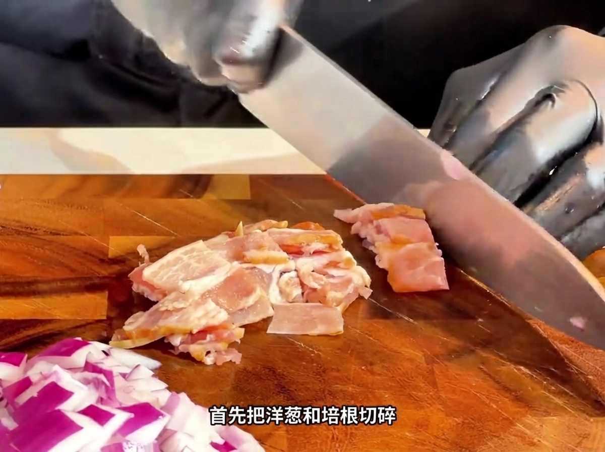Un coltello che affetta la pancetta cruda a striscioline su un tagliere di legno.