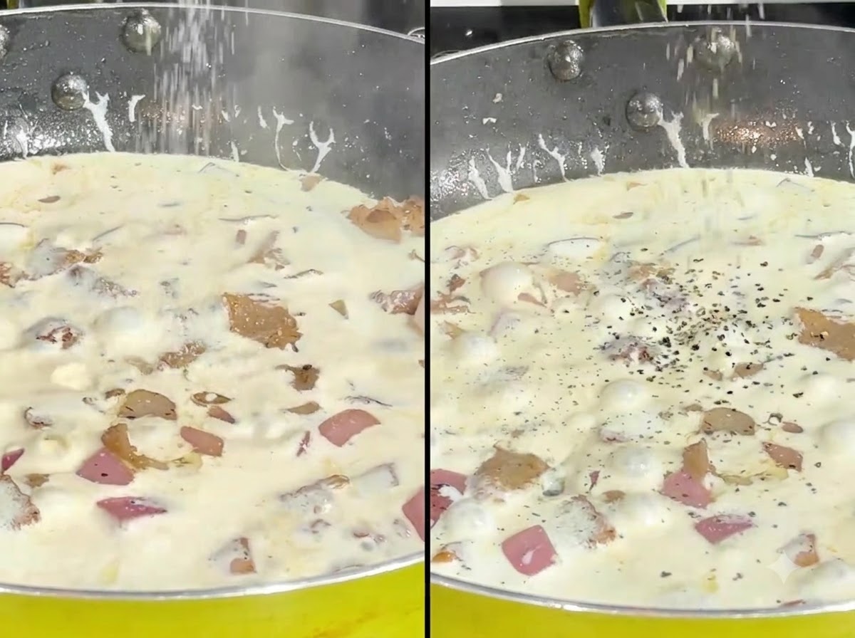 Sale e pepe nero macinato sparsi su una salsa alla crema che sobbolle in padella.