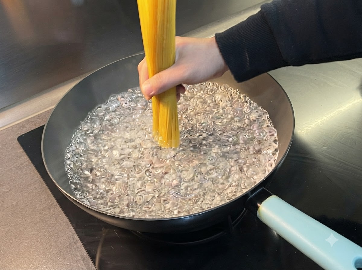 Una mano immerge un mazzo di spaghetti in una pentola dacqua bollente.