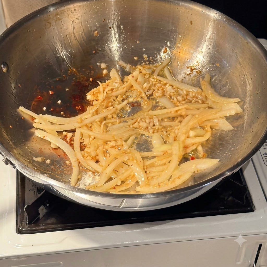 Vino bianco versato in una padella contenente cipolle e aglio soffritti.
