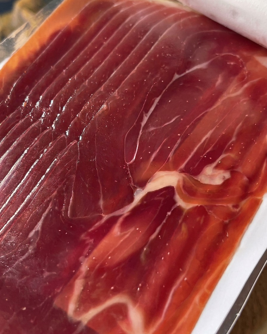 Primo piano di fette di prosciutto disposte ordinatamente pronte per essere adagiate sui fichi.