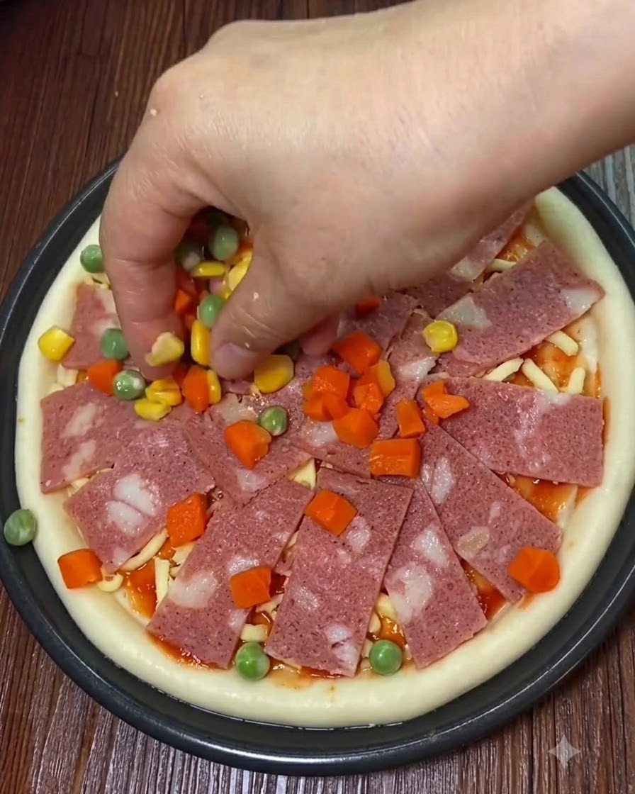Fette di pancetta, mais dolce e verdure a cubetti posizionati sulla pizza.