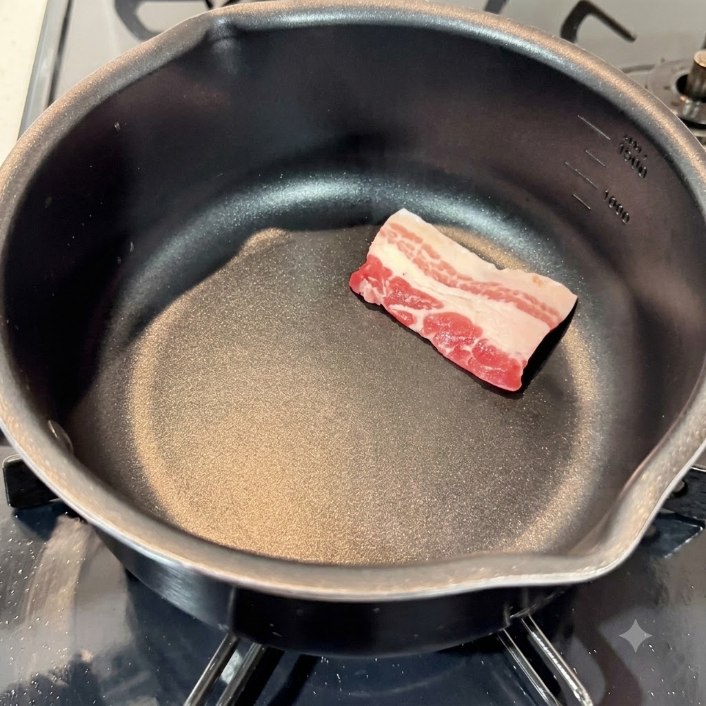 Fette crude di pancetta di maiale disposte in una pentola da cucina nera vuota.