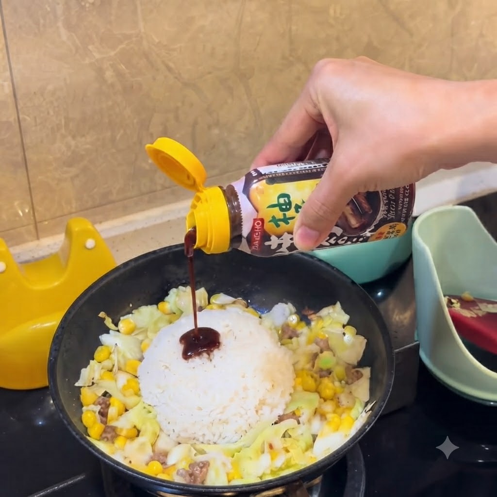 Una bottiglia di salsa barbecue saporita che viene premuta per versare la salsa scura sul mucchio di riso bianco nella padella.
