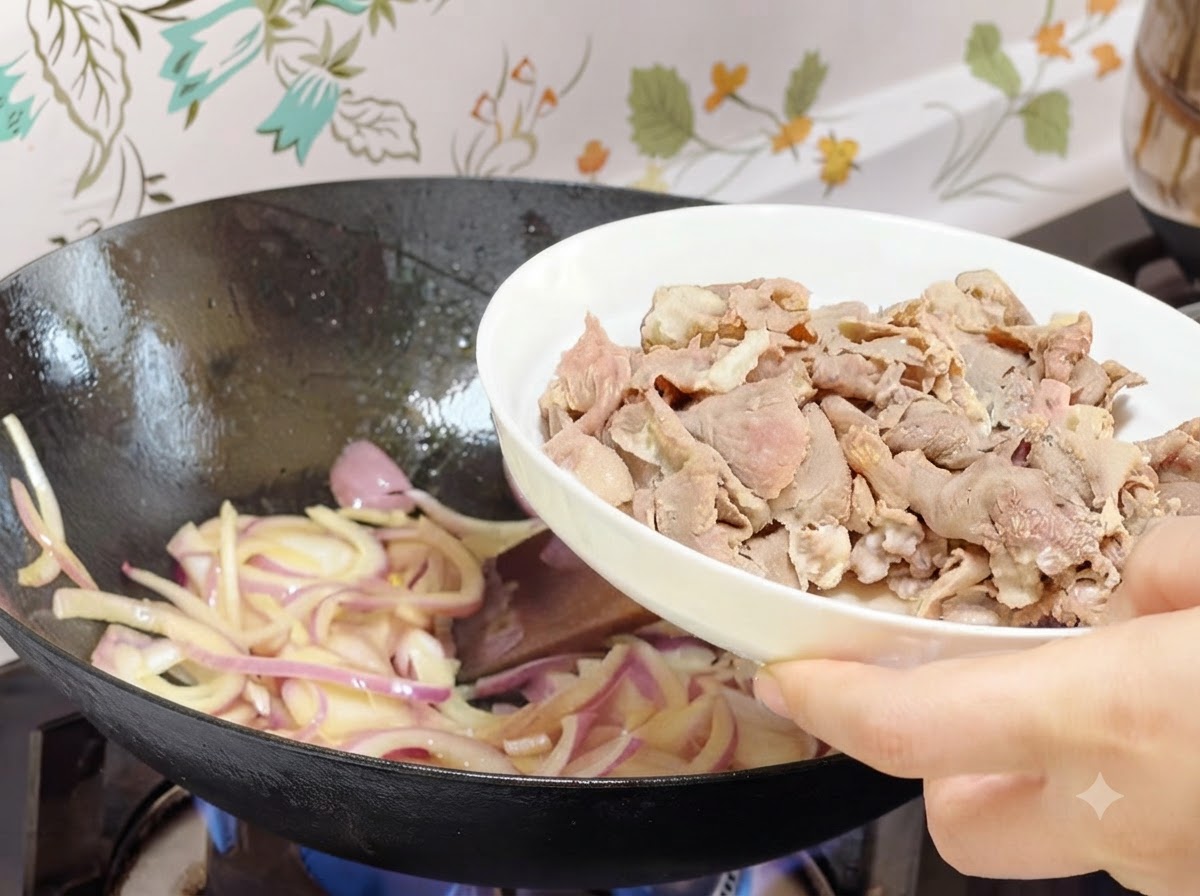 Involtini di manzo pre-sbollentati versati da un piatto bianco nel wok con le cipolle cotte.