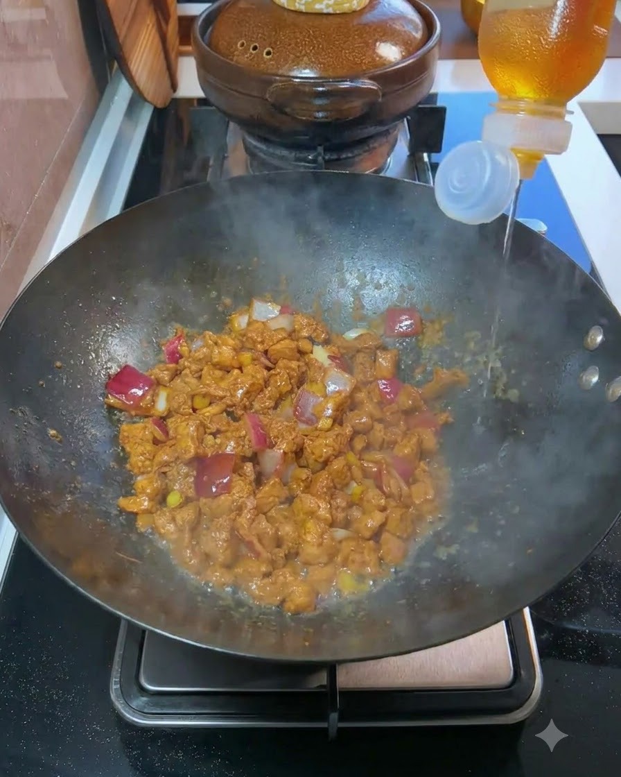 Vino da cucina versato da una bottiglia in un wok contenente carne cotta e cipolle a cubetti.