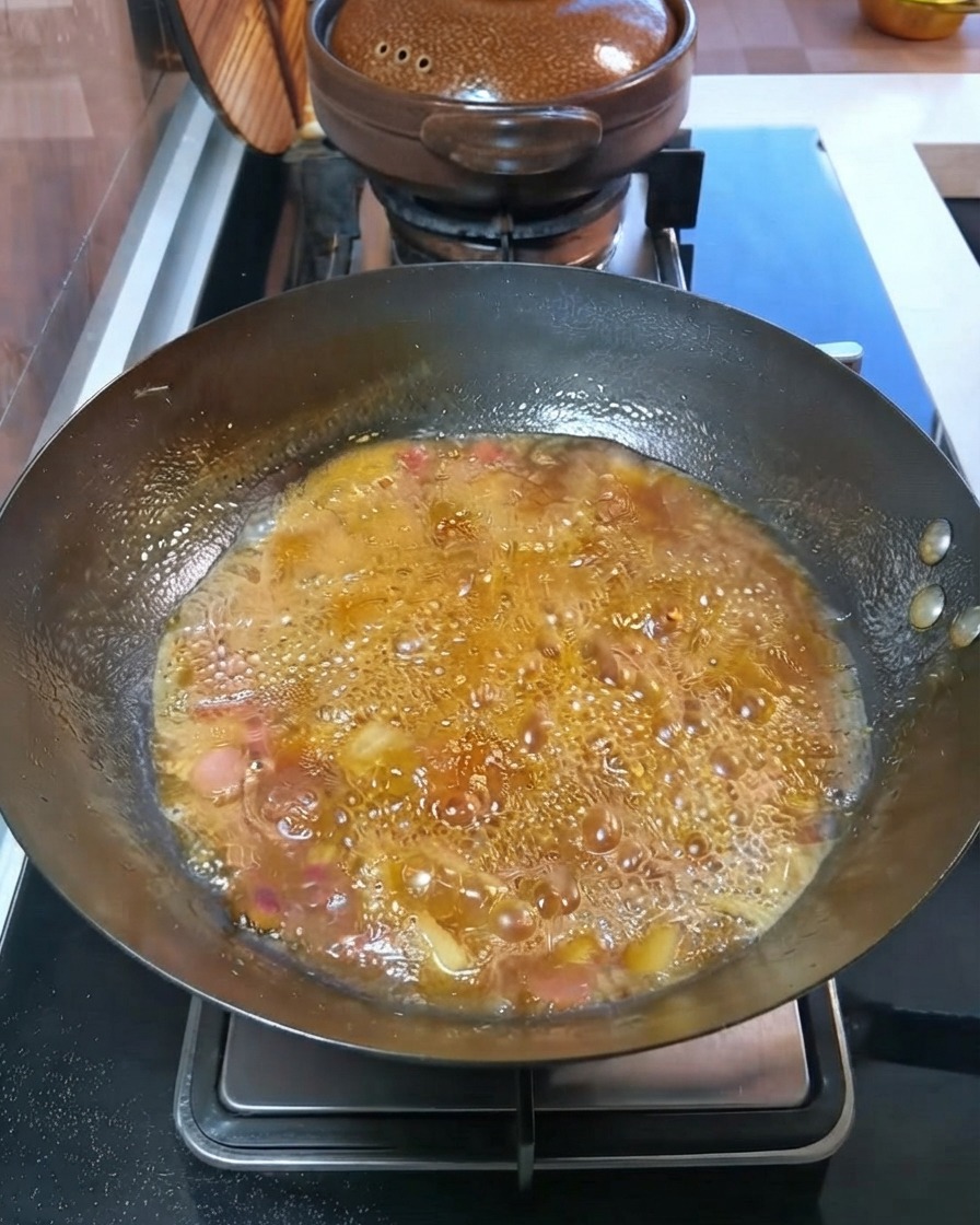 Patate e carote a cubetti che sobbollono in un brodo bollente allinterno del wok.