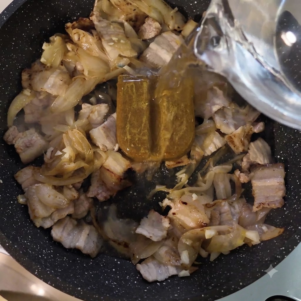 Acqua versata da un contenitore nella padella sopra la pasta di curry e la carne.