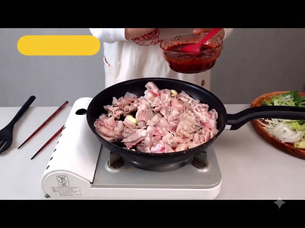 Pancetta di maiale tagliata sottile che cuoce in padella rilasciando il proprio grasso.