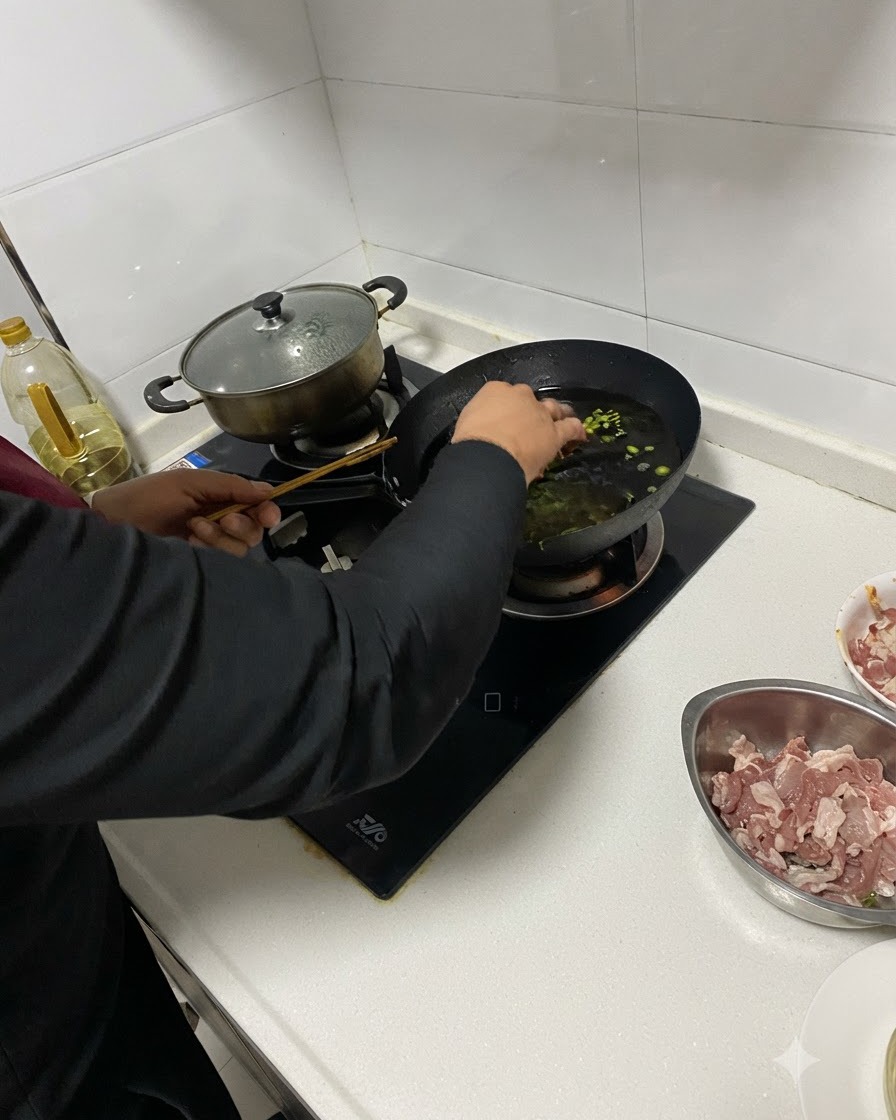 Aromi tritati aggiunti nellolio caldo in un wok usando le bacchette.
