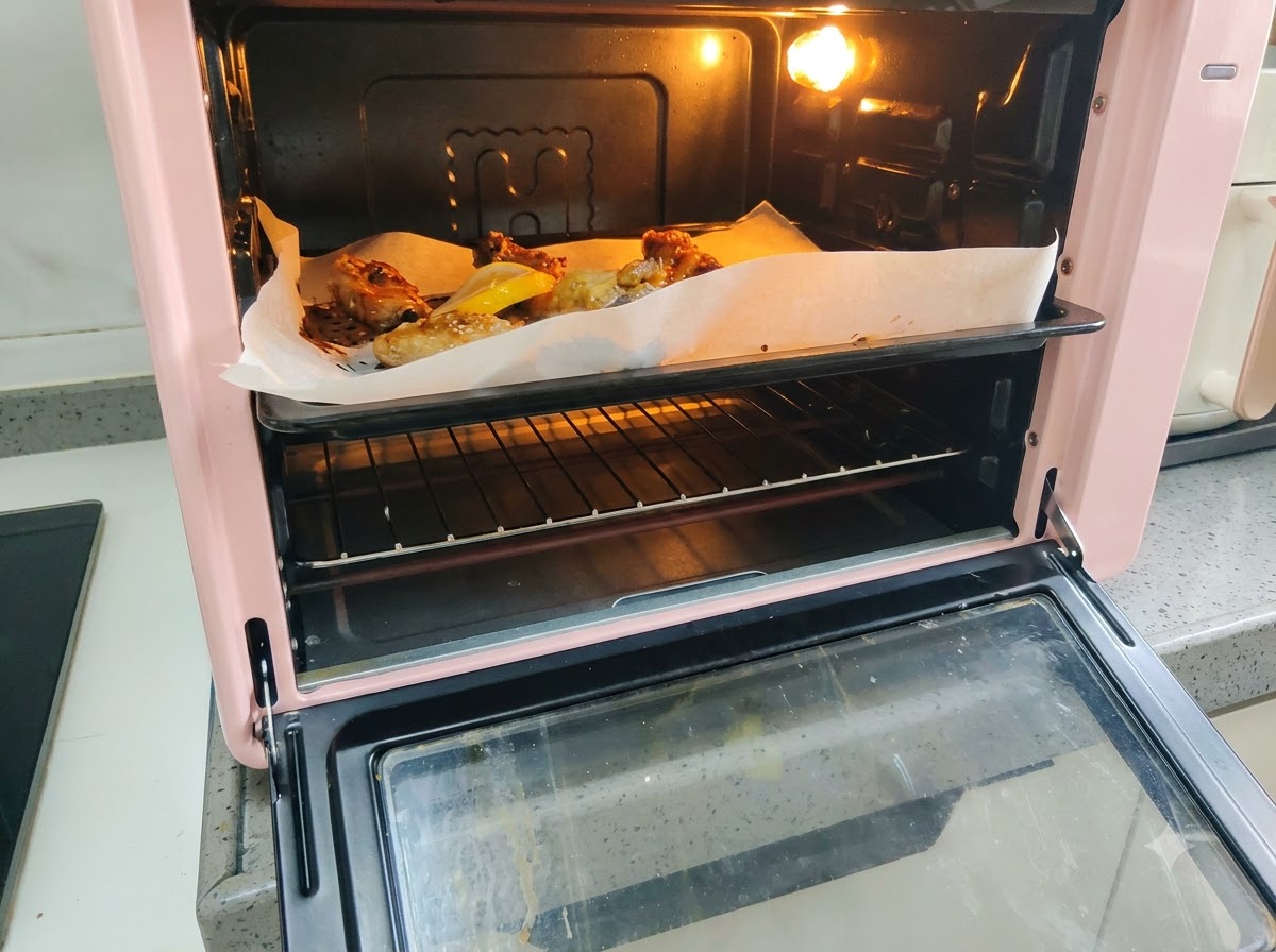 Fette di limone fresco disposte sulla teglia accanto alle costine di maiale in cottura.
