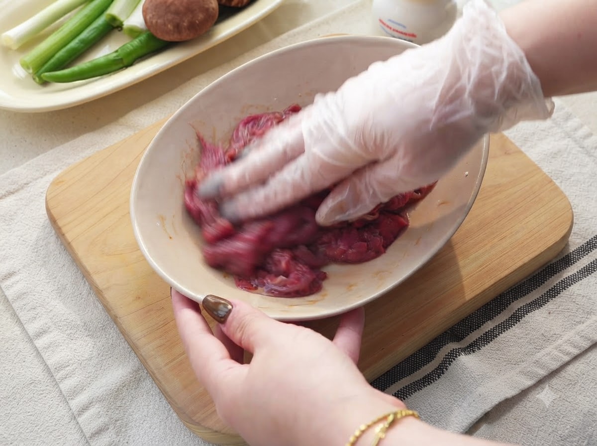 Cipolle, peperoncini verdi e aglio tagliati su un tagliere di legno.