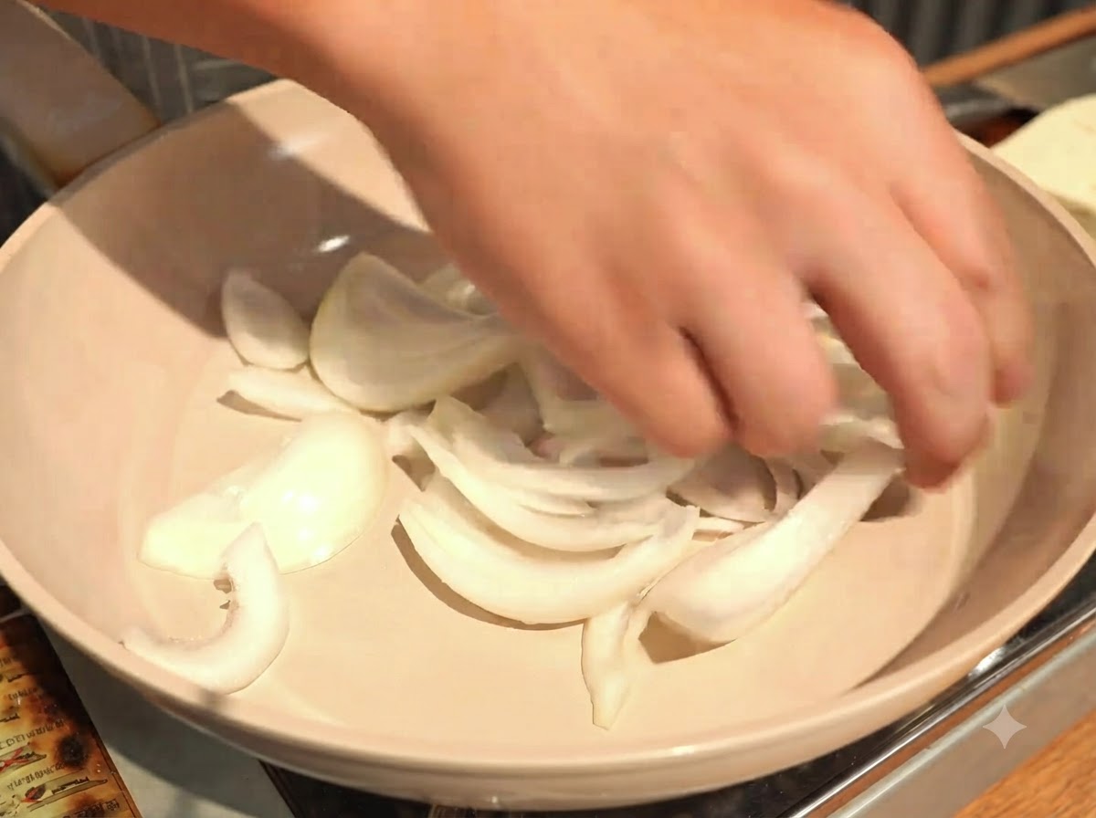 Spargere le cipolle affettate in modo uniforme sul fondo di una padella di cottura bassa.
