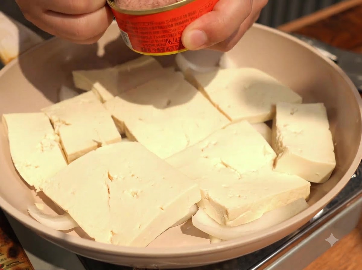Mettere pezzi di tonno in scatola direttamente al centro delle fette di tofu disposte.