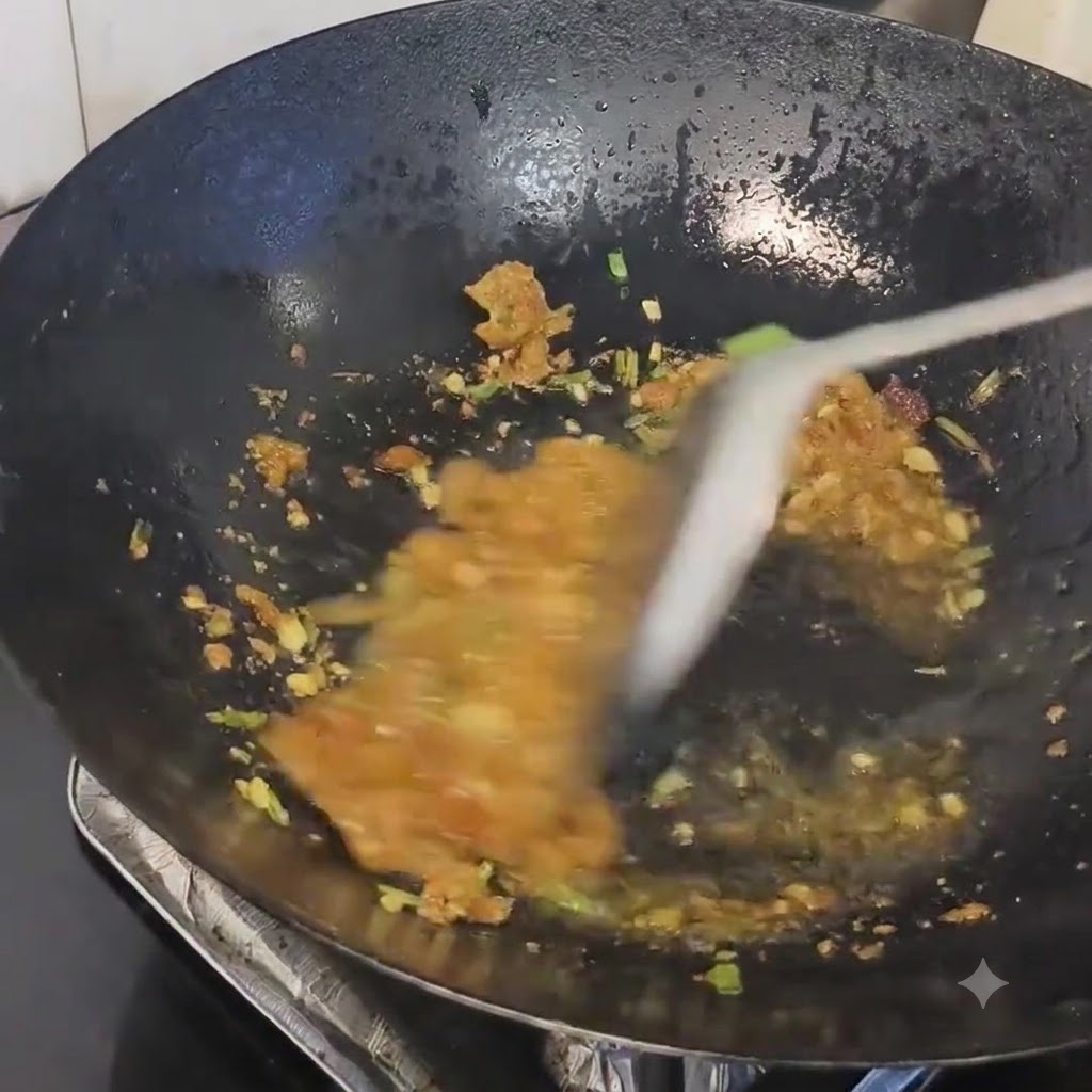 Residui di strutto di maiale mescolati agli aromi saltati in un wok caldo.