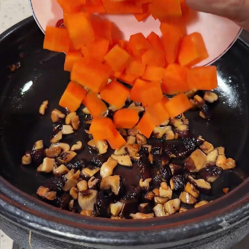 Carote a cubetti arancioni vivaci versate da un piatto nella pentola contenente i funghi saltati.