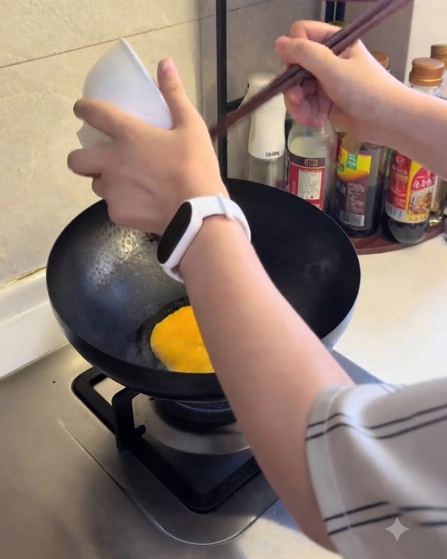 Uovo sbattuto versato in una padella calda per cuocere.