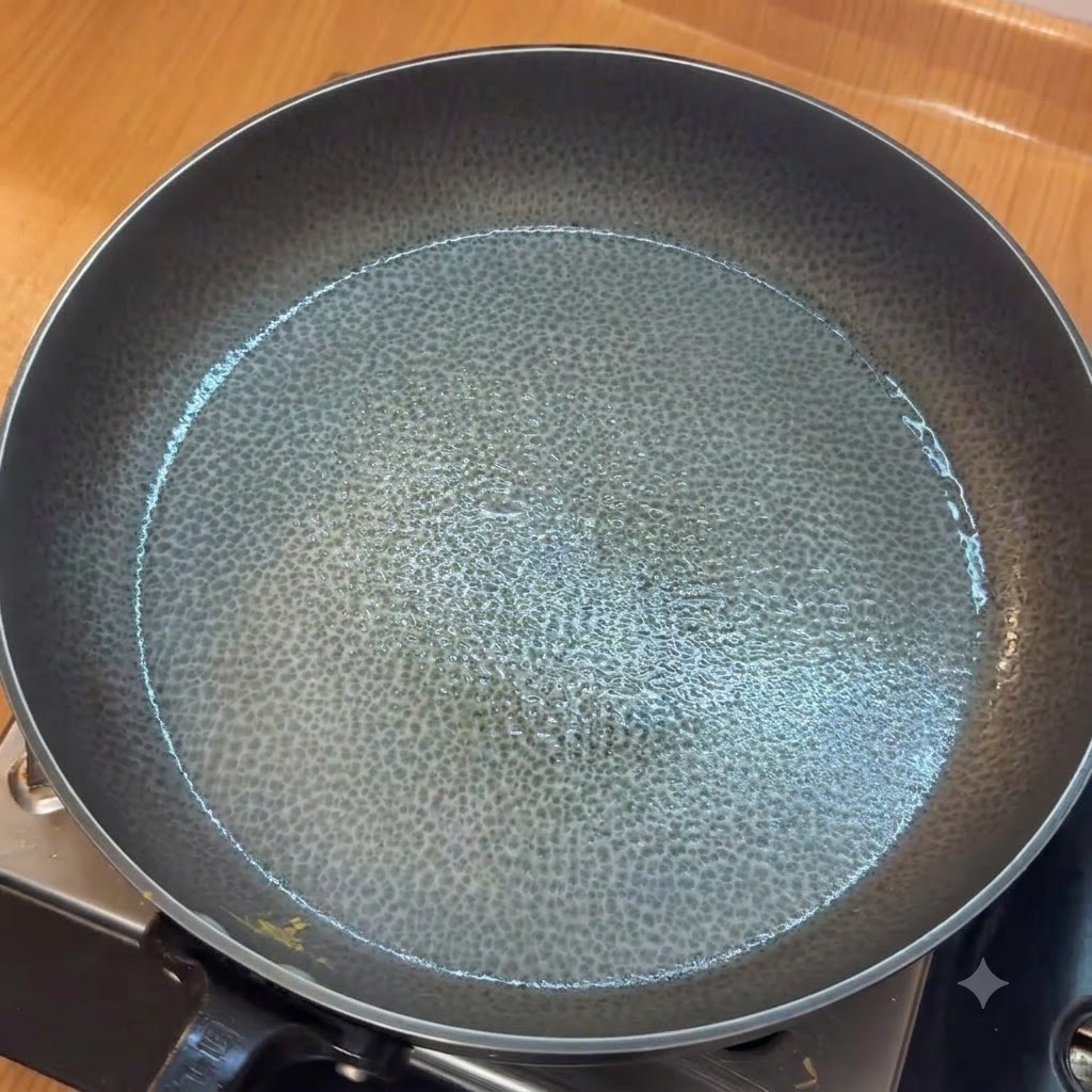 Aglio tritato che soffrigger in una padella unta prima di aggiungere i pomodori tritati.