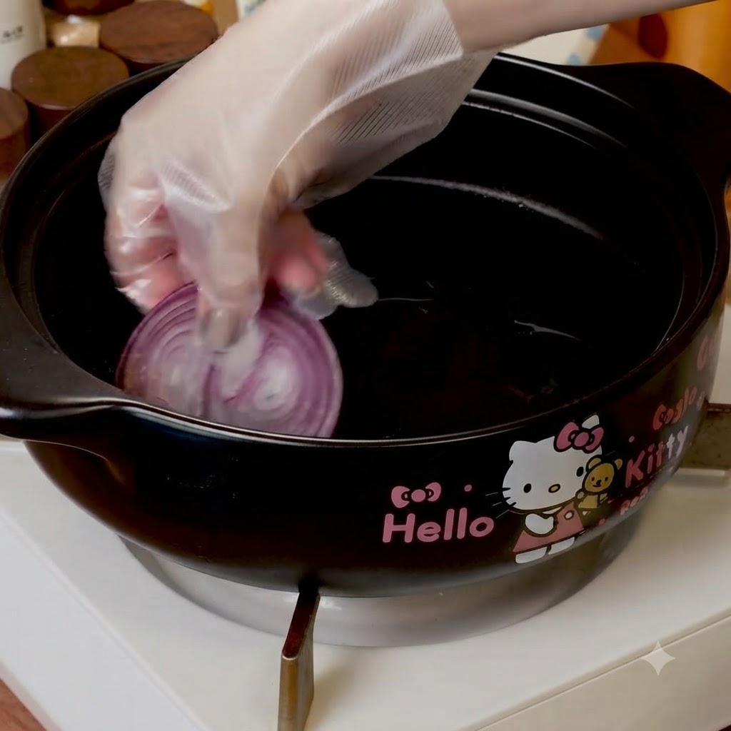 Fette di cipolla rossa disposte sul fondo di una pentola da cucina nera.