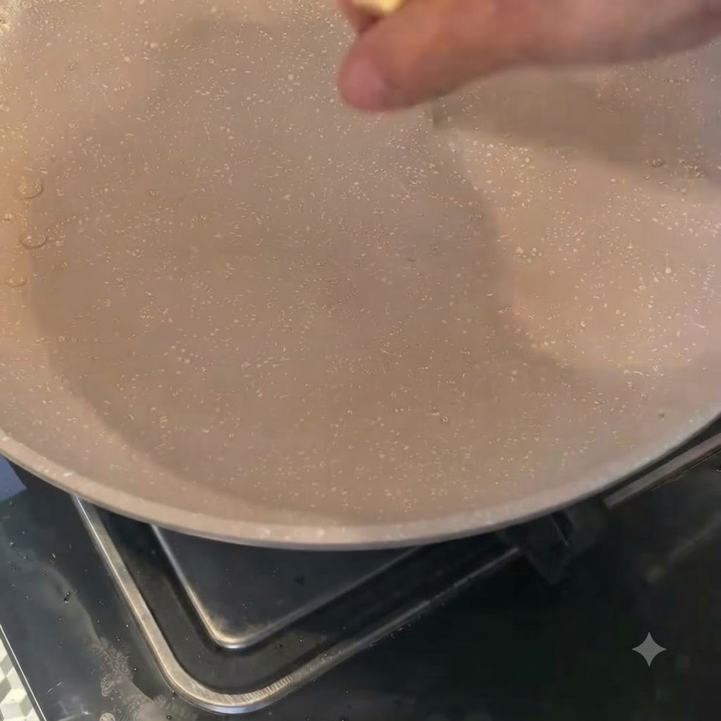 Cipolle tritate che cuociono nel burro fuso allinterno di una padella bassa.