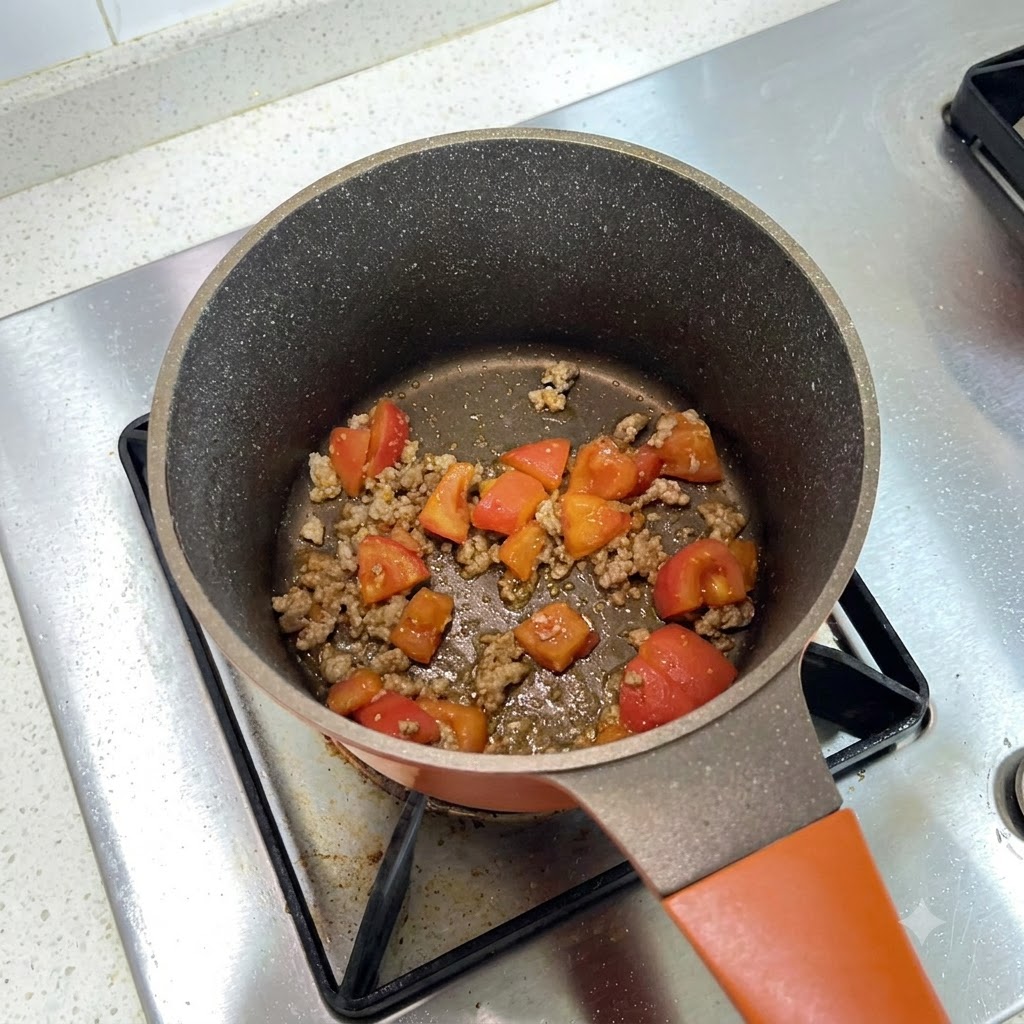 Una pentola da cucina riempita con un miscuglio di carne macinata e pomodori a dadini mentre viene condita.
