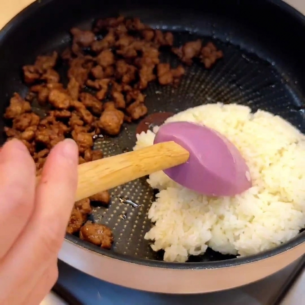 Riso bianco cotto posizionato accanto alla carne macinata cotta allinterno di una padella.