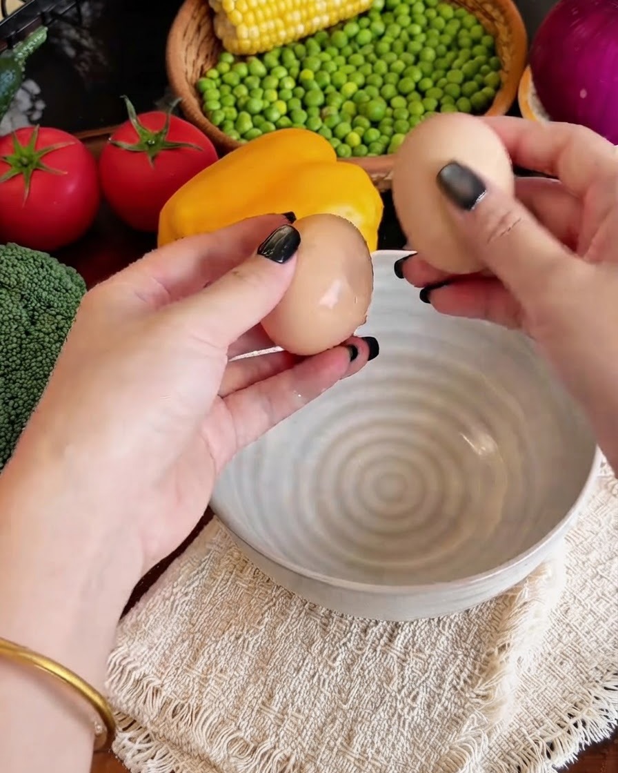 Uova rotte in una ciotola con bastoncini di surimi sfilacciati e latte.