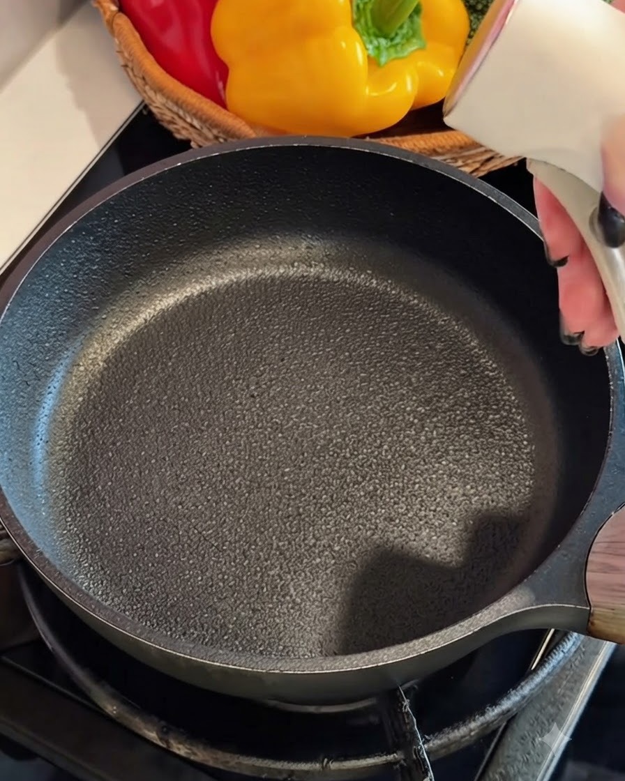 Composto di uova e surimi versato in una padella calda unta dolio.