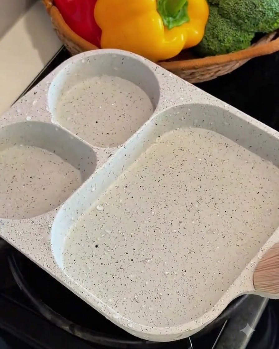 Uovo sbattuto versato e arrotolato in strati dentro una padella quadrata.