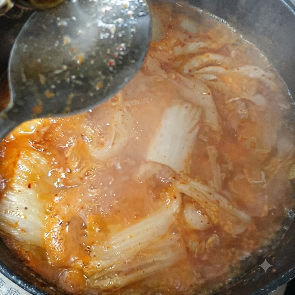 Salsa di soia e peperoncino in polvere mescolati in una pentola di stufato di kimchi bollente.