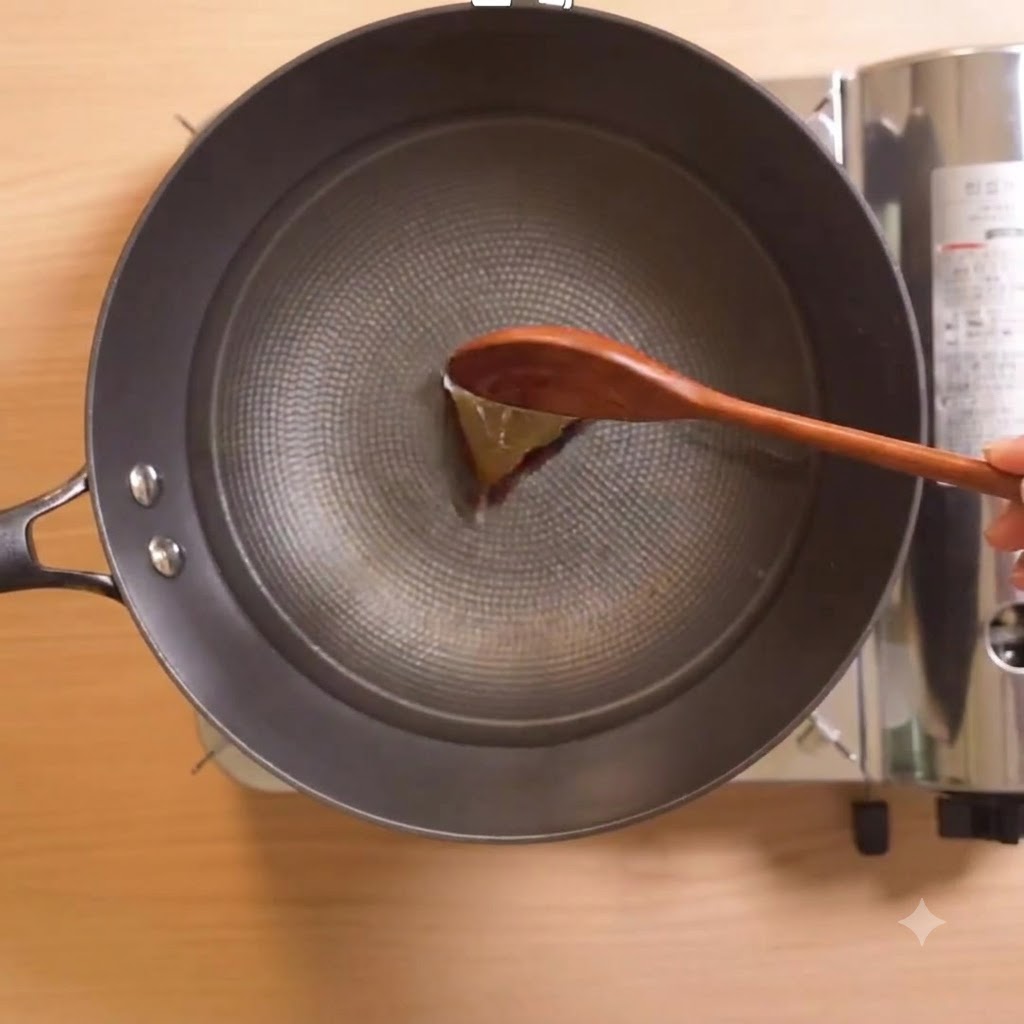 Salsa di pesce e aglio tritato mescolati in una pentola con un cucchiaio di legno.