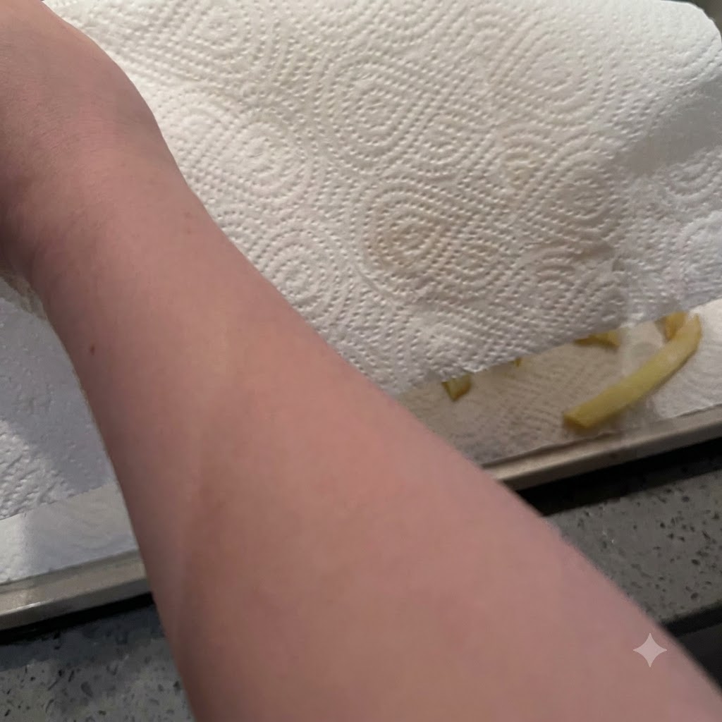 Carta da cucina utilizzata per premere e asciugare i bastoncini di patate umidi disposti su un vassoio.