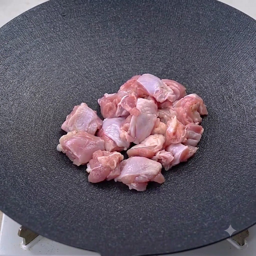 Pezzi di coscia di pollo crudi in una padella nera.